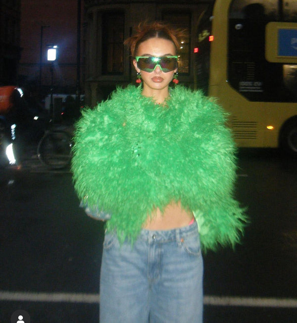 Fashionable woman in sunglasses and a Green Faux Fur Coat.