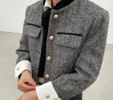 Woman wearing Grey Tweed Cropped Jacket with buttons, a stylish outerwear choice.