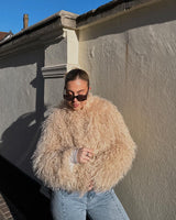 Woman in Beige Faux Sheep Jacket leaning against wall