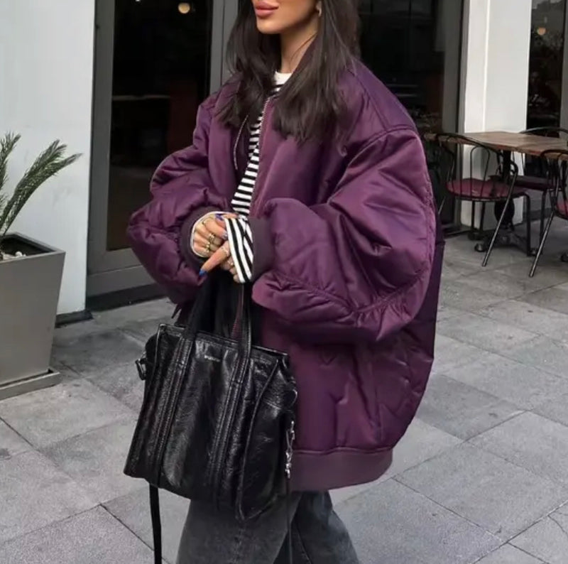 A woman in a purple jacket and black jeans.