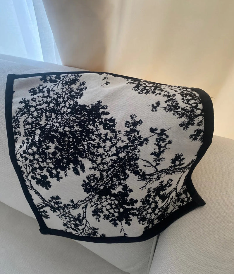 Black and white scarf elegantly draped on a white couch, showcasing the stylish Black and White Branch Cushion.