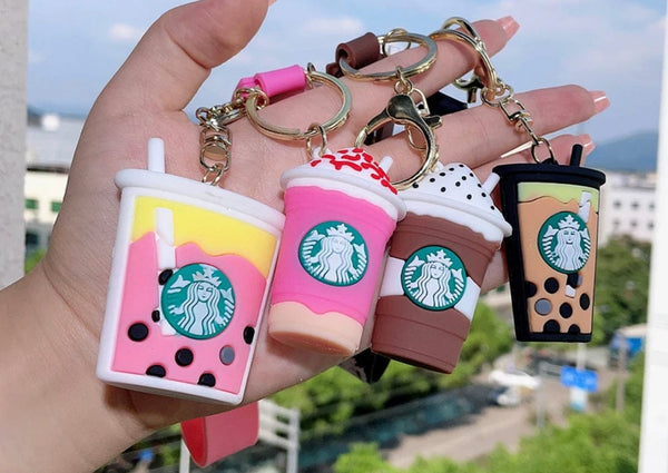 A Starbucks Keyring, a hand holding a cup-shaped keychain with the Starbucks logo.