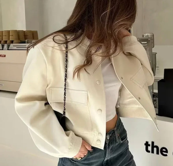 Stylish woman in white jacket and jeans, showcasing Pocket bomber jacket.