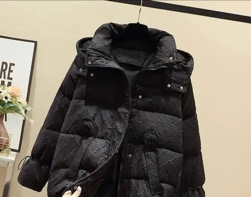 Down Puffer Jacket Longline - black puffy coat hanging on a wall.