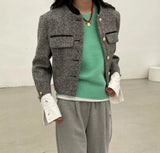 A woman in grey sweatpants and a green sweater, showcasing the Grey Tweed Cropped Jacket.