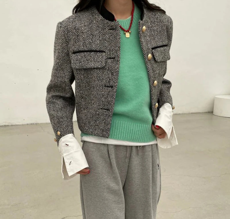 A woman in grey sweatpants and a green sweater, showcasing the Grey Tweed Cropped Jacket.