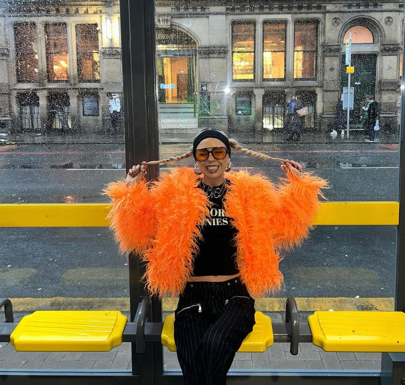 Lady in trendy Orange Faux Fur Jacket and sunglasses