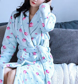 An image of a woman relaxing on a couch, dressed in a Blue and Pink Cherry Bath Robe.