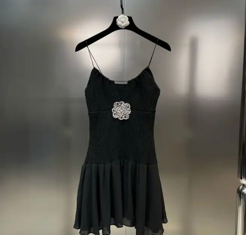 Black Flower Mini Dress - stylish black dress hanging on a hanger.