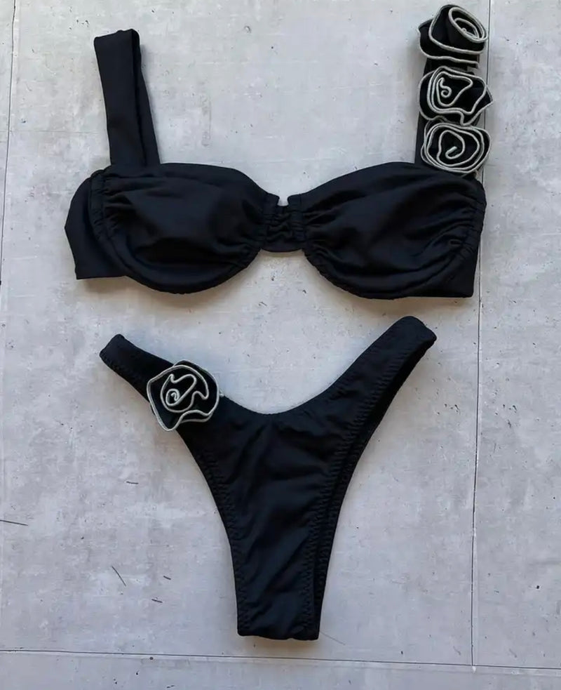 Stylish black bikini with a floral accent, ideal for sunny beach getaways