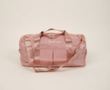 A personalized pink duffel bag with the word "simply" on it, perfect for a weekend getaway.