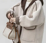 A woman in a white coat and brown boots holding a bag, wearing a Wool Two Piece Hoody Jacket