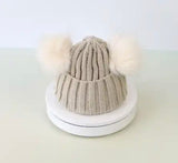 Stay warm and stylish with this Baby And Kids Beanie featuring two cute pom poms on top