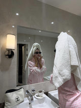 Female in Pink Checked Feather Pyjamas brushing teeth in bathroom