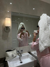 Woman in Pink Checked Feather Pyjamas brushing teeth in bathroom