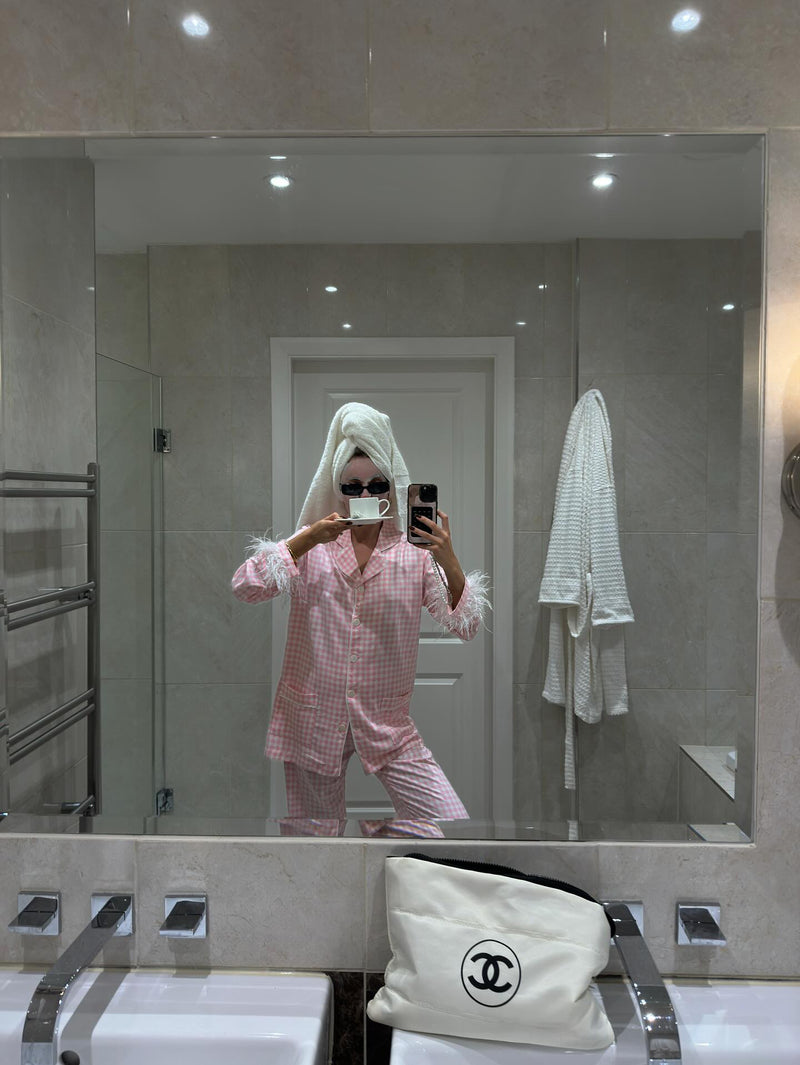 Woman in Pink Checked Feather Pyjamas bunny suit taking a selfie in bathroom mirror